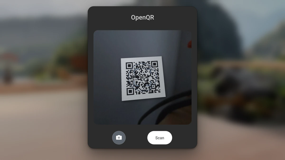 The OpenQR scan panel on a Quest 3 with a printed QR code lined up in the scan area under the target ring, a camera button and a Scan button.
